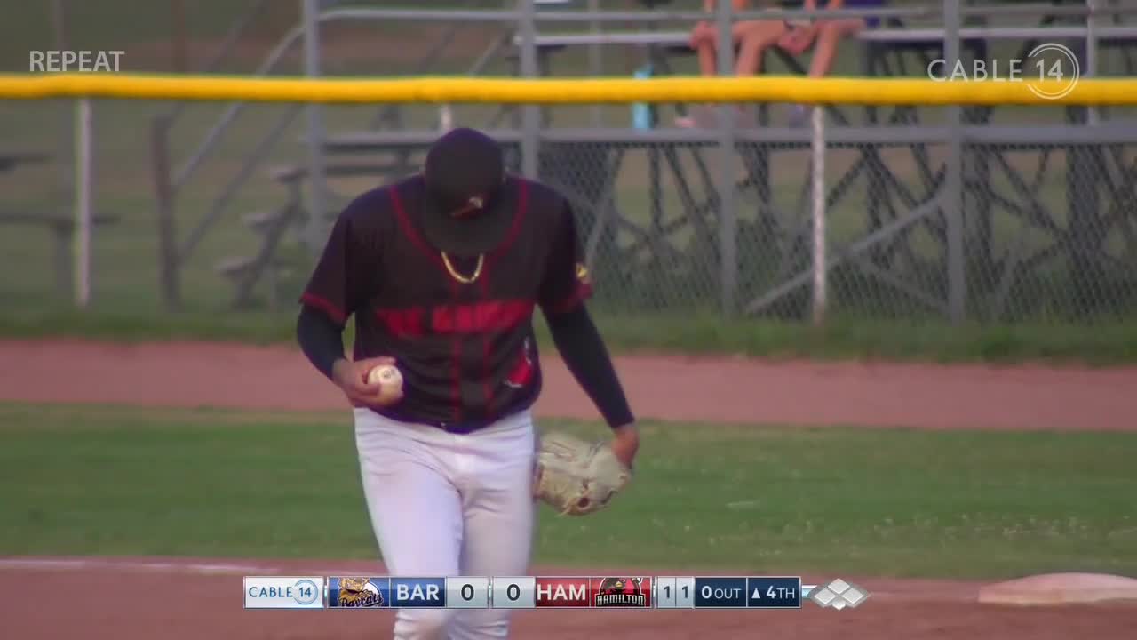 The pitcher, clad in a black and red jersey, holds the baseball in his left hand, the glove dangling at his side. It's the fourth inning, and the Hamilton team is up by one, as Cable 14 Hamilton broadcasts the game.

