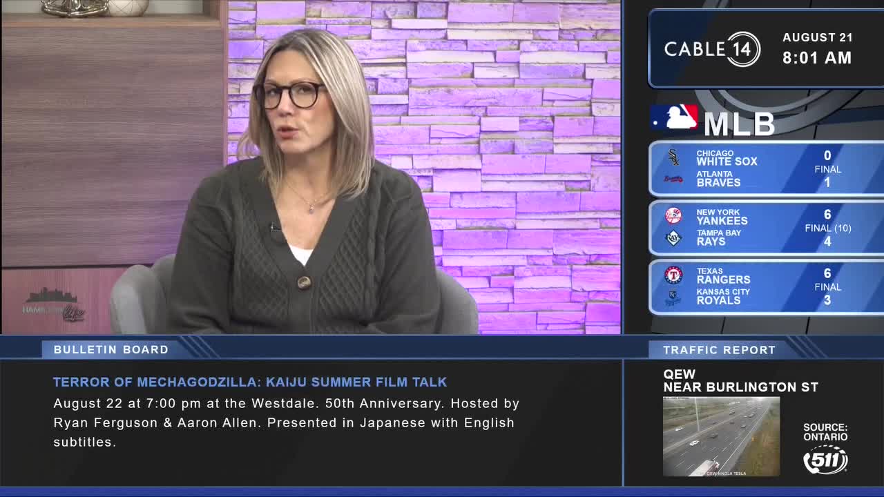 The Cable 14 Hamilton anchor is speaking, her gaze directed towards the camera. Baseball scores and a traffic report flash on the screen beside her.
