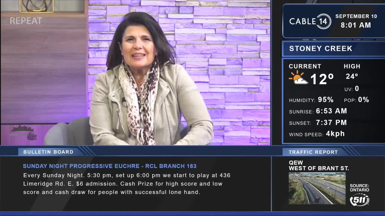 A woman in a light jacket and scarf is speaking from a Cable 14 studio. The screen displays the weather in Stoney Creek, Ontario, and a traffic report for the QEW.
