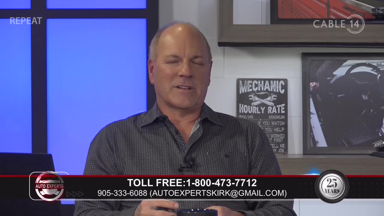 A man in a patterned shirt is speaking, likely on Cable 14 in Hamilton, Canada. The Auto Experts logo and contact information appear at the bottom of the screen.
