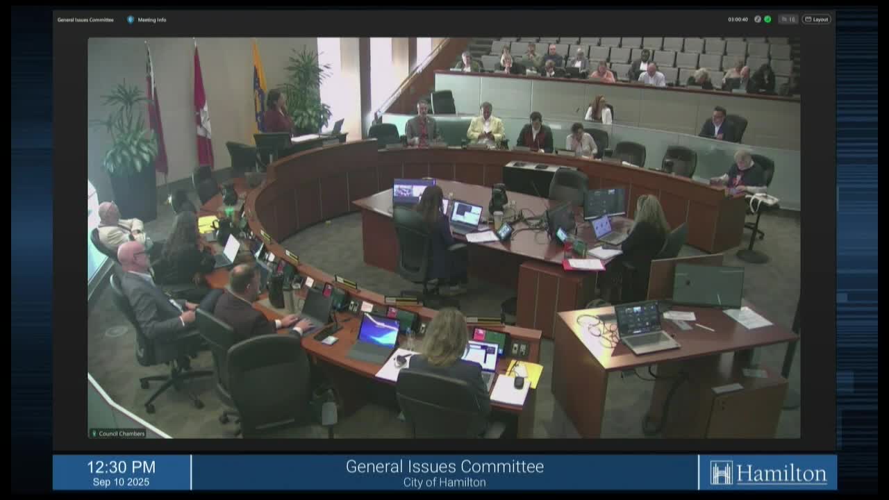 The General Issues Committee of the City of Hamilton is in session, with members seated around a curved table. Cable 14 Hamilton is broadcasting the meeting, with a view of the council chambers.
