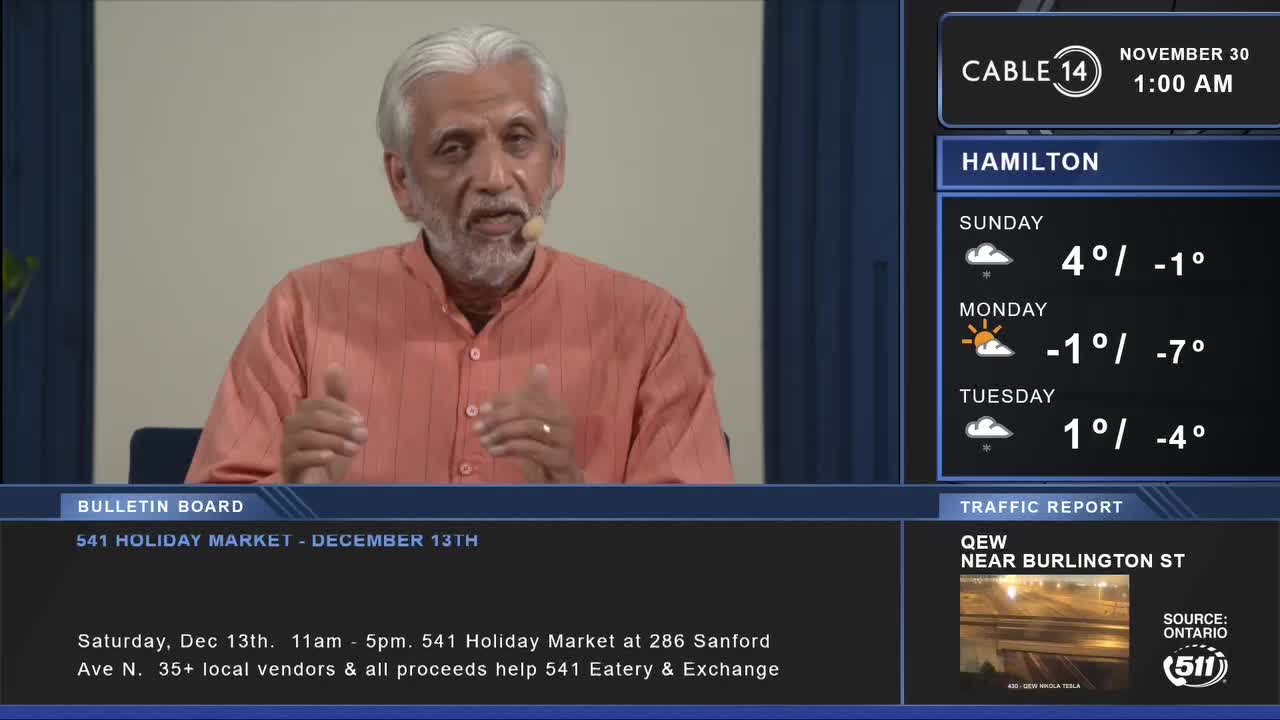 A man in an orange shirt gestures with his hands, speaking into a microphone on Cable 14. The screen displays the weather forecast for Hamilton and a bulletin about a holiday market.
