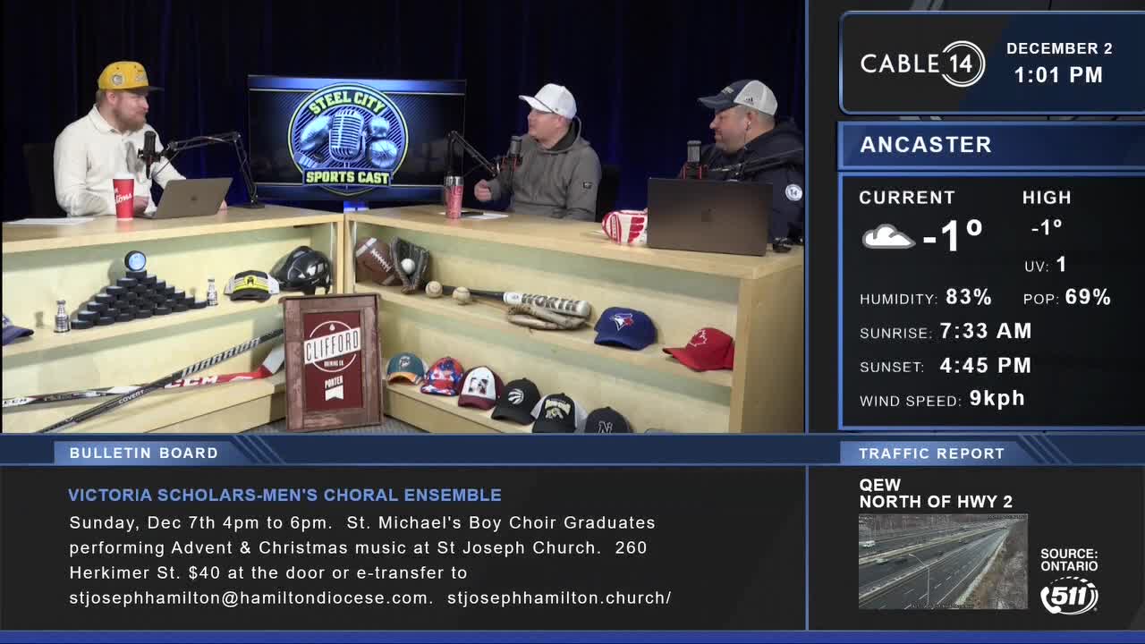 Three men are seated at a table, microphones in front of them, discussing sports on Cable 14 in Hamilton, Ontario. The temperature in Ancaster is -1 degrees Celsius, according to the on-screen display.
