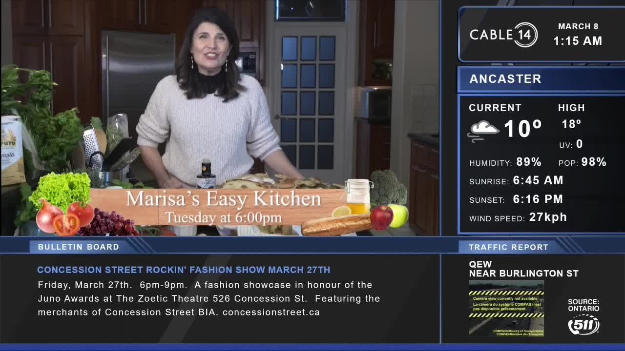 A woman stands in a kitchen, a spread of fresh produce in front of her. Cable 14 Hamilton displays the current Ancaster weather, showing 10 degrees Celsius.