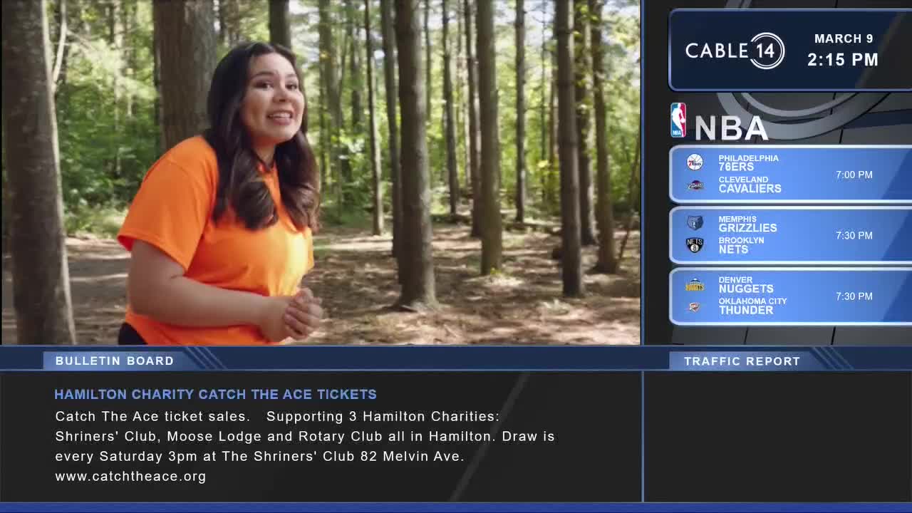 A young woman in an orange shirt speaks animatedly in a sun-dappled forest. On the right, Cable 14 Hamilton displays NBA game times and a bulletin board announces a charity draw in Hamilton.