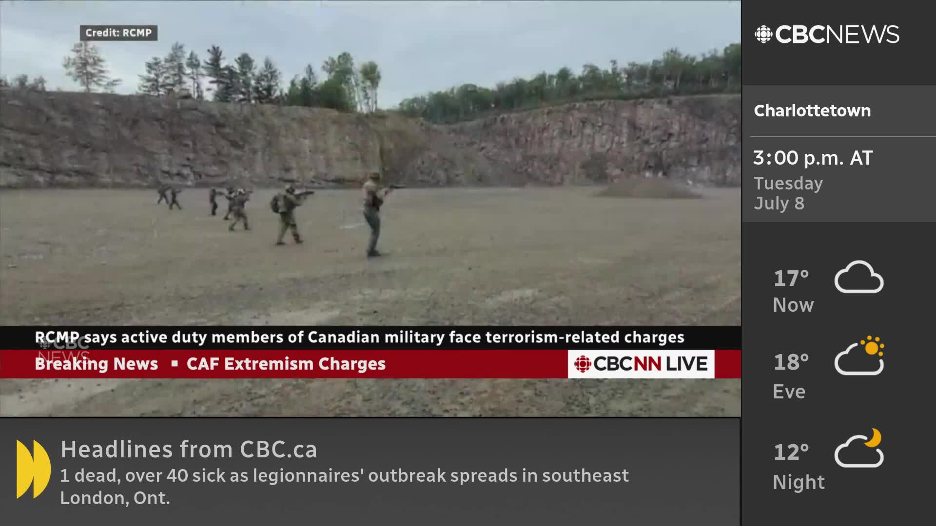 In a dusty, open area, several figures in military gear are holding rifles, some facing forward.  The CBC News Network is reporting on the RCMP's announcement regarding terrorism-related charges against Canadian military members.
