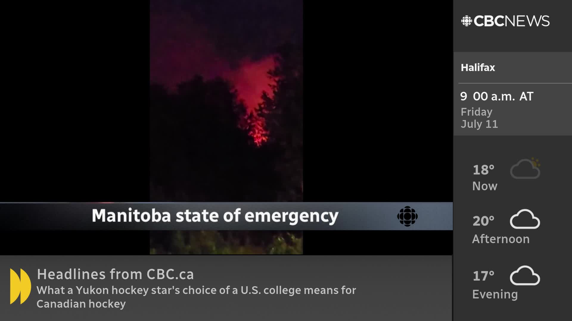 Crimson light flares above the treeline, a stark contrast against the night. The CBC News Network is reporting on a state of emergency in Manitoba.
