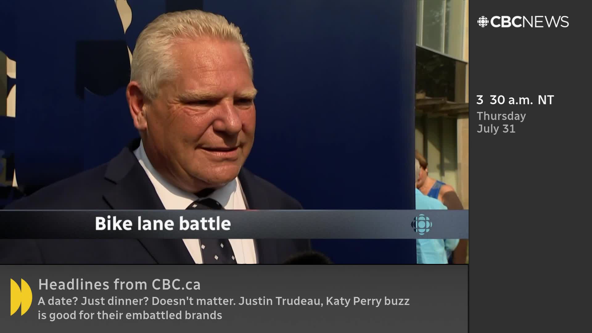 A man in a dark suit and tie is speaking on camera, the words "Bike lane battle" displayed below him. The CBC News Network logo and the date and time are visible on the right side of the screen.
