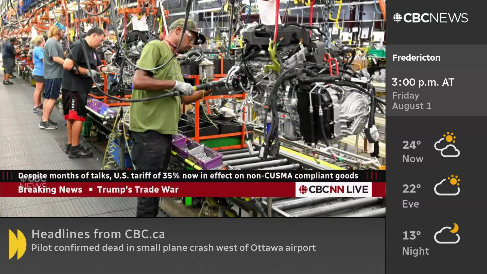 Workers assemble what looks like an engine on a conveyor belt, each focused on their task. The CBC News Network is reporting on trade tariffs and the weather in Fredericton.
