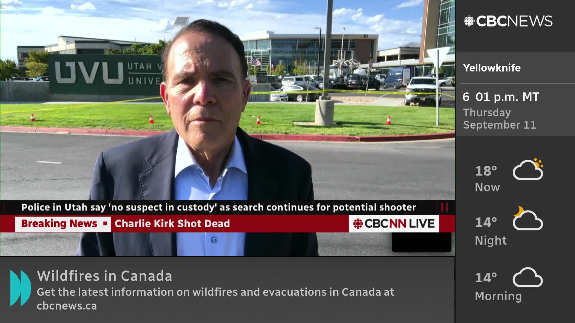 A CBC News Network reporter stands in front of a university building, delivering a live report. Behind him, police vehicles are visible near what appears to be a crime scene, with yellow tape strung up.
