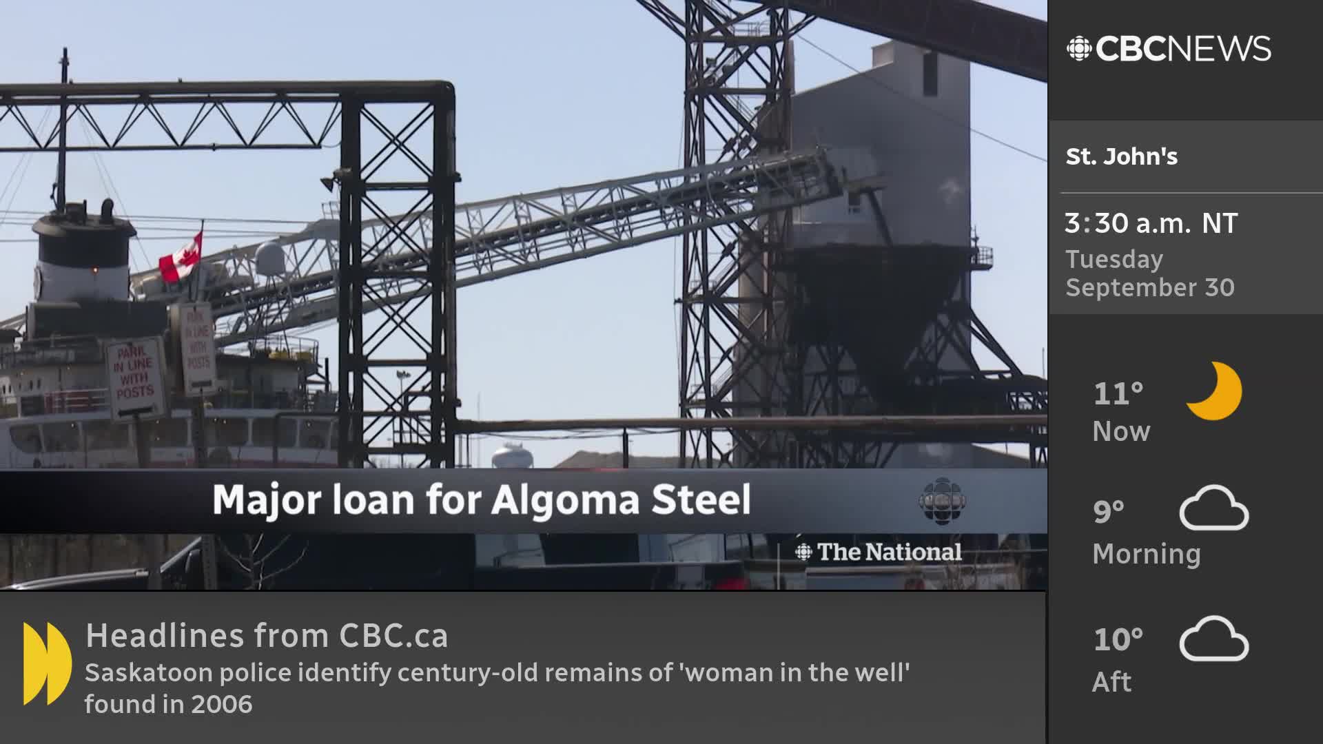 A large industrial complex, possibly a steel mill, dominates the scene, with a ship displaying a Canadian flag in the foreground. The CBC News Network logo and a headline about a major loan for Algoma Steel are displayed on the screen.
