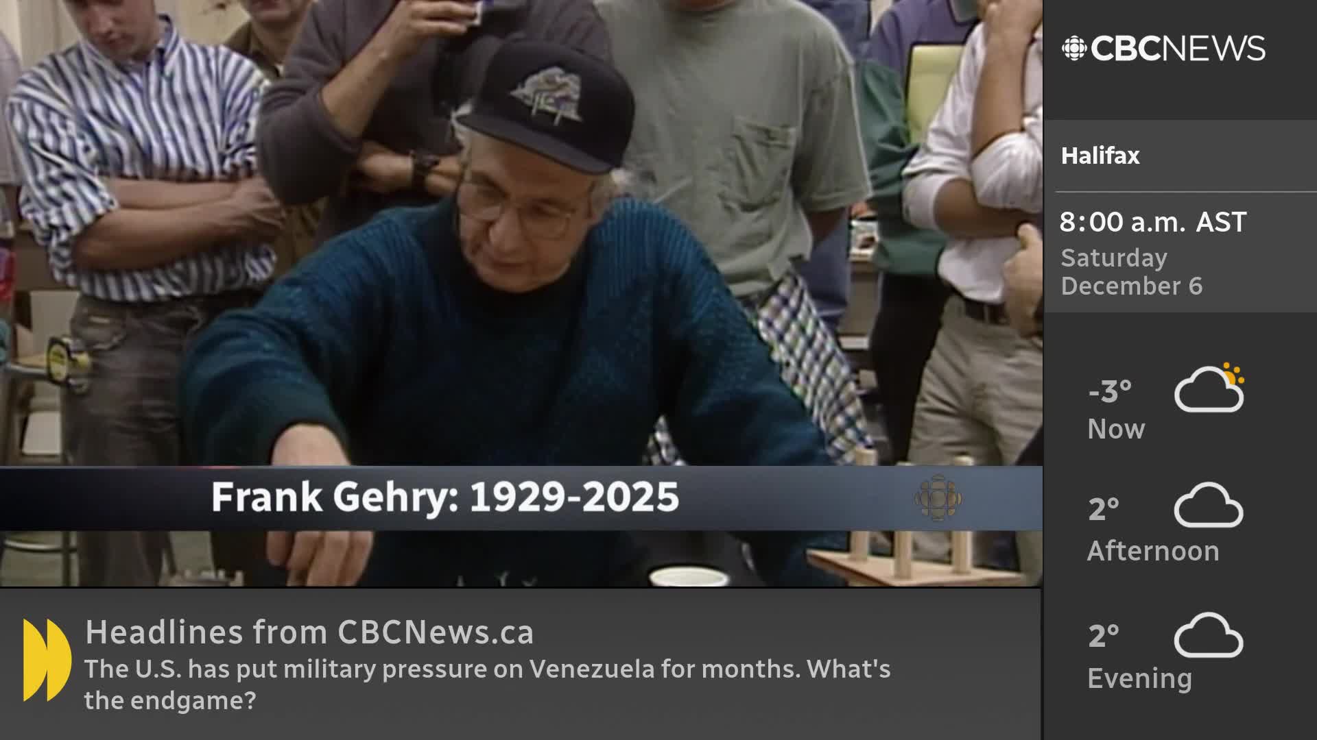An older man in a cap and glasses leans forward, his hands working over a small model. CBC News Network is on, and the Halifax weather report shows a chilly -3 degrees.
An older man in a cap and glasses leans forward, his hands working over a small model. CBC News Network is on, and the Halifax weather report shows a chilly -3 degrees.