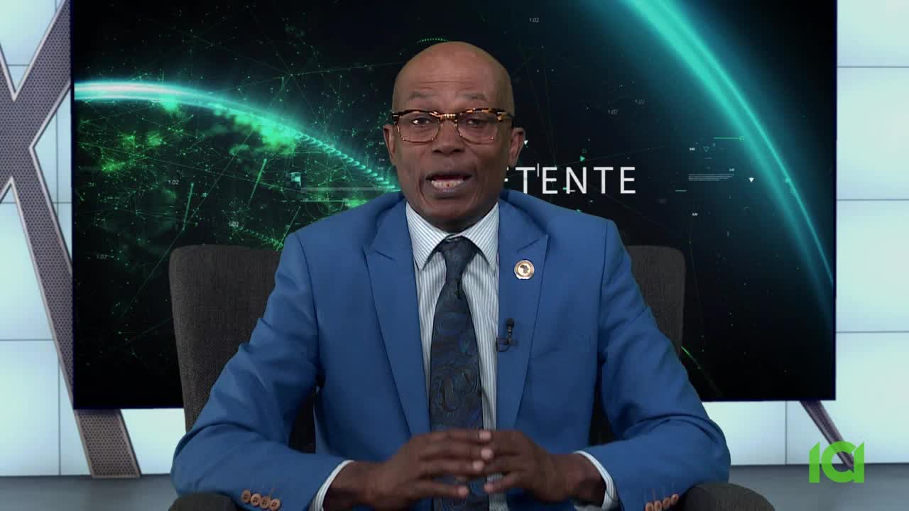 A man in a blue suit and glasses speaks directly to the camera, likely on CFHD-DT in Canada. Behind him, a green graphic of a globe and network lines provides the backdrop.
