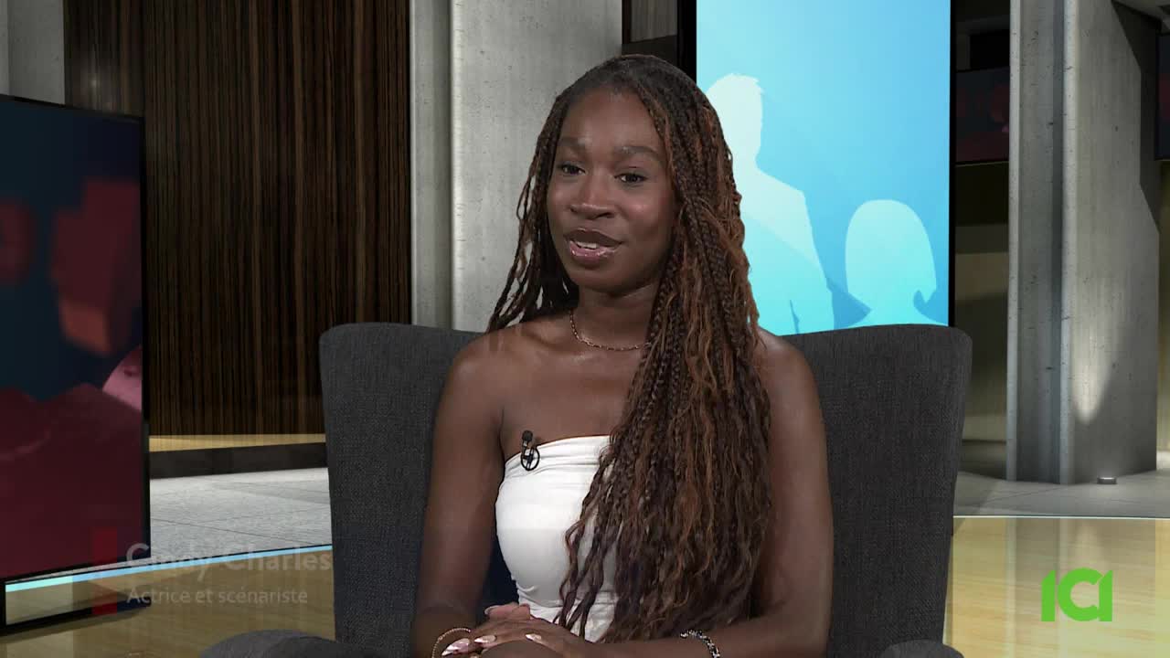 A woman with long, braided hair sits in a chair, speaking into a microphone. The CFHD-DT logo is visible in the corner, and the backdrop is a simple, modern studio setting.
