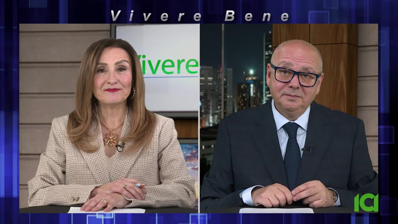 A woman in a checkered blazer and a man in a dark suit sit side-by-side on CFHD-DT, each framed by a different background. They're in a studio, ready to discuss "Vivere Bene" on Canadian television.
