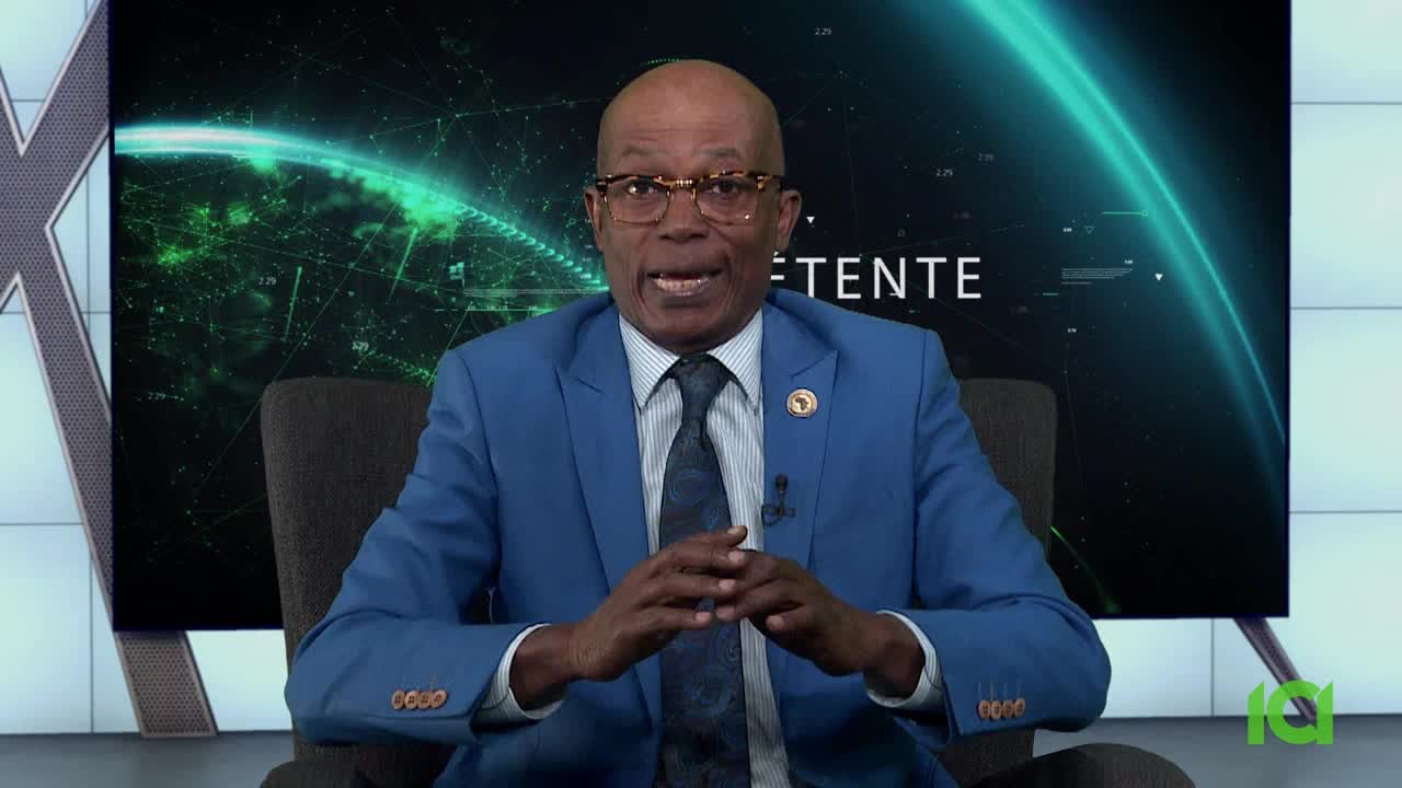 A man in a blue suit, wearing glasses, sits in a chair, gesturing with his hands. Behind him, a screen displays a glowing green graphic, and the CFHD-DT logo is visible on the bottom right.
