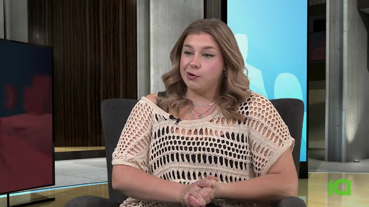 A woman with blonde hair is speaking, her hands clasped in front of her. The background includes a large screen and a modern-looking set, likely for a program on CFHD-DT.
A woman with blonde hair is speaking, her hands clasped in front of her. The background includes a large screen and a modern-looking set, likely for a program on CFHD-DT.