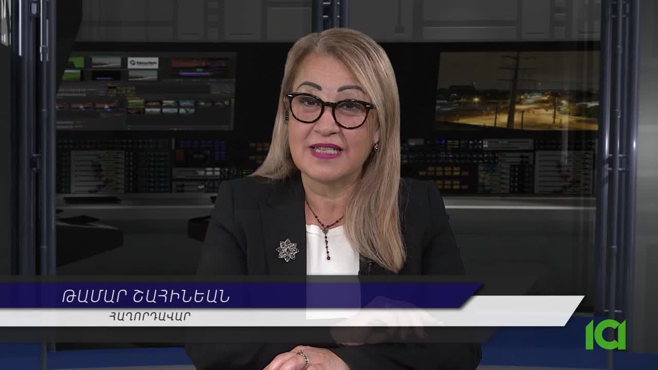A woman in glasses and a black blazer is speaking, the camera focused on her from the chest up. Behind her, a background shows a studio set with monitors and a night scene, likely from Canada's CFHD-DT.
