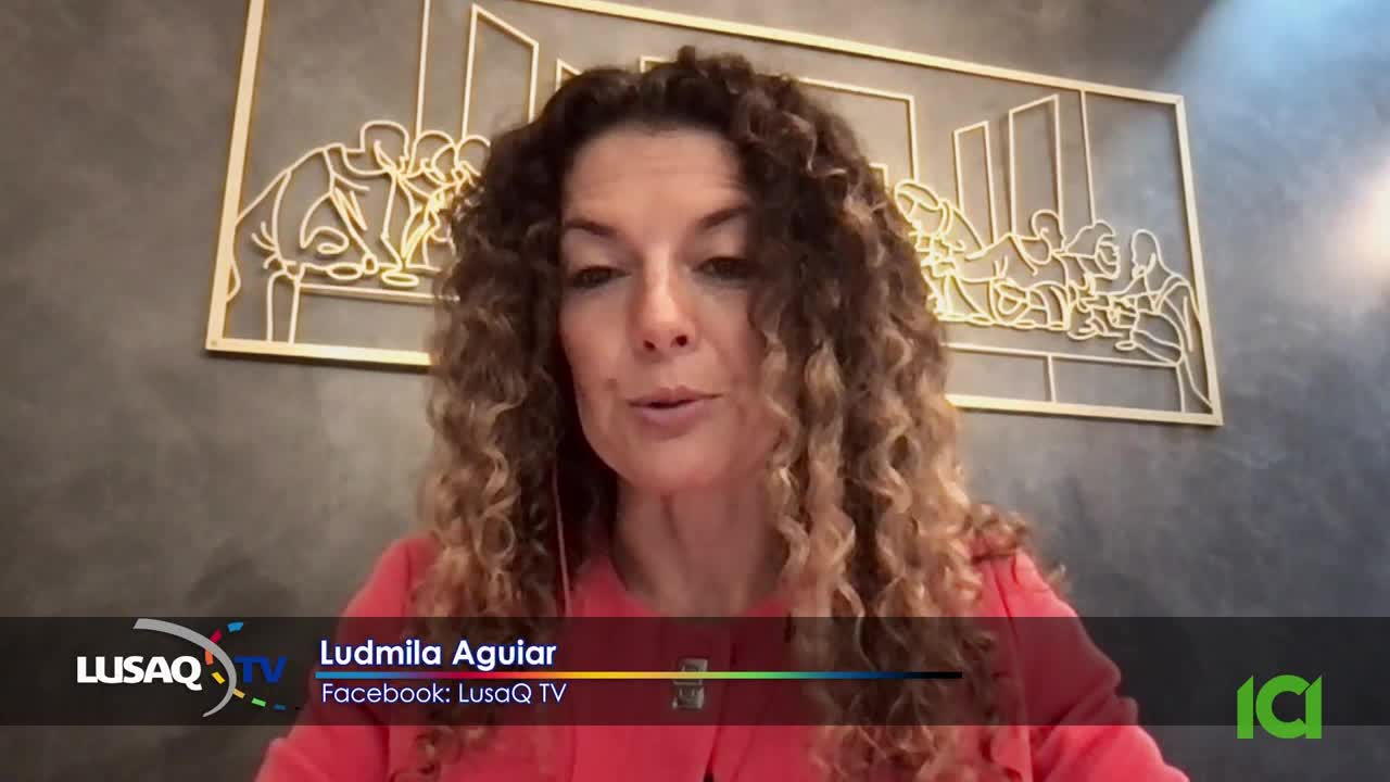 Ludmila Aguiar, on LusaQ TV, is speaking directly to the camera, her curly hair framing her face. A decorative piece hangs behind her, and the logo for CFHD-DT is visible on the screen.
