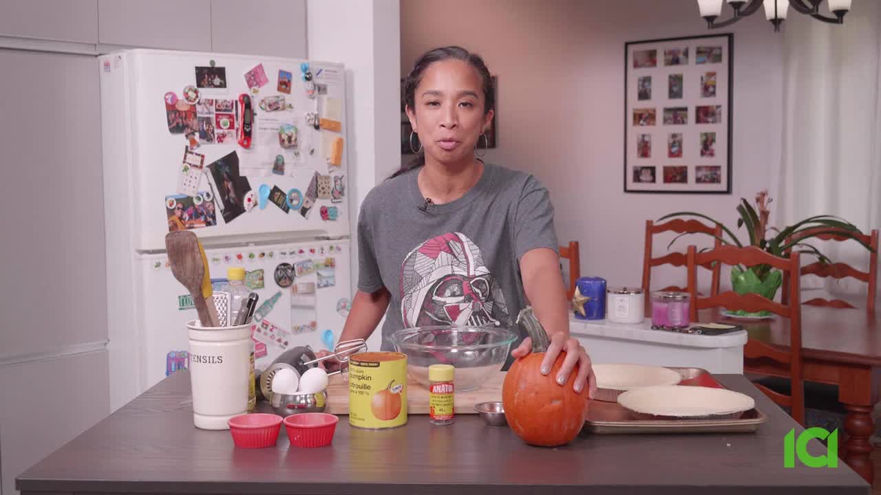 A woman in a Star Wars t-shirt stands at a table, surrounded by ingredients for a pie. Beside her is a whole pumpkin and a can of pumpkin puree, ready to be used on CFHD-DT in Canada.
