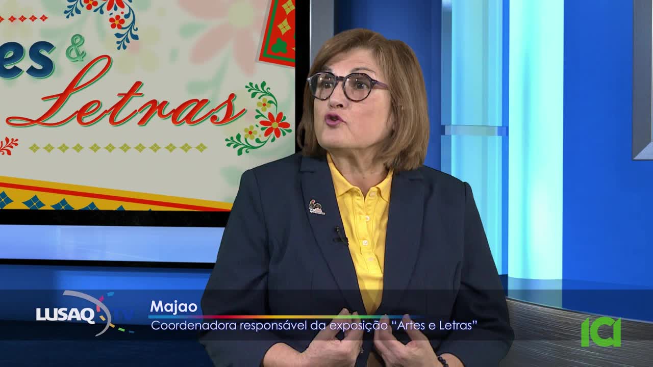 A woman in a dark blazer and yellow shirt speaks animatedly. Behind her, a screen displays "Artes & Letras" in stylized script.