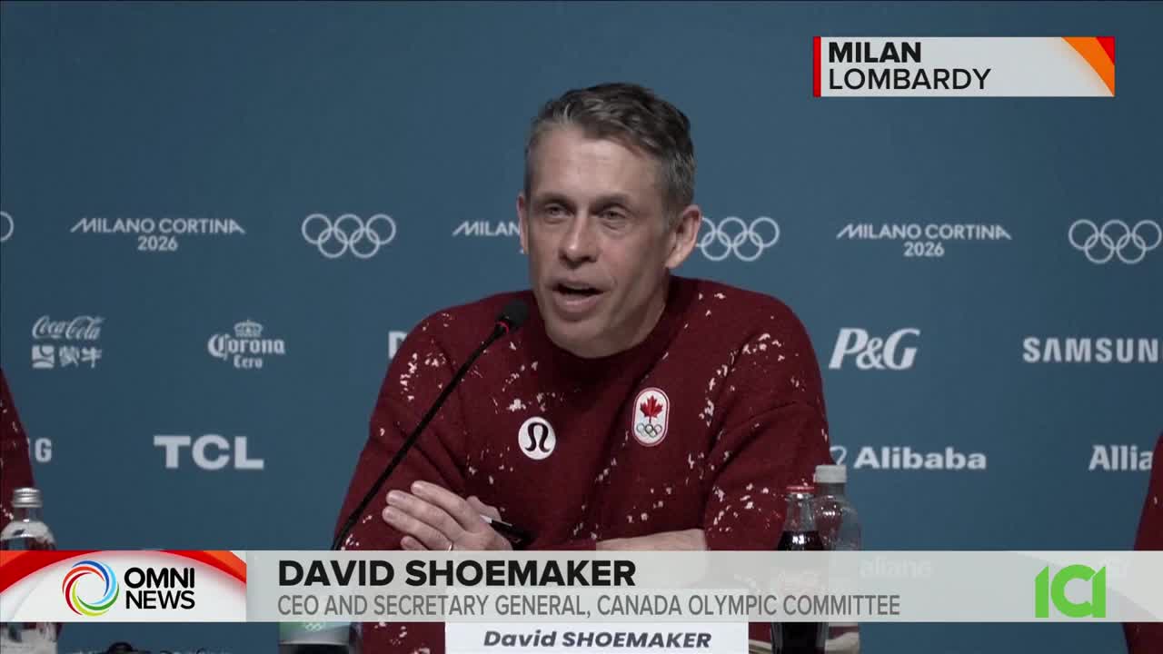 David Shoemaker, CEO and Secretary General of the Canada Olympic Committee, speaks at a press conference. The backdrop displays "MILANO CORTINA 2026" and various sponsor logos.
