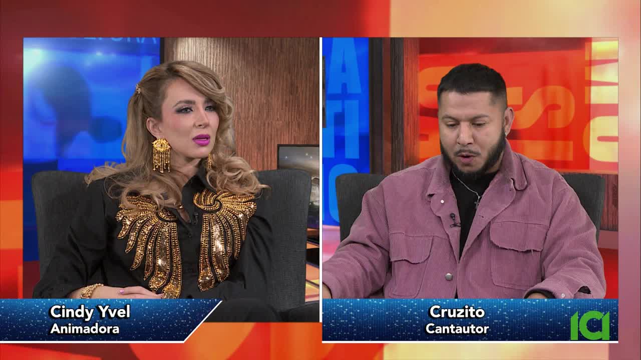 A woman with blonde hair and large gold earrings speaks, her black shirt adorned with shimmering gold accents. Across from her, a man with a beard in a mauve jacket looks down as if speaking. The CFHD-DT logo is visible in the corner.