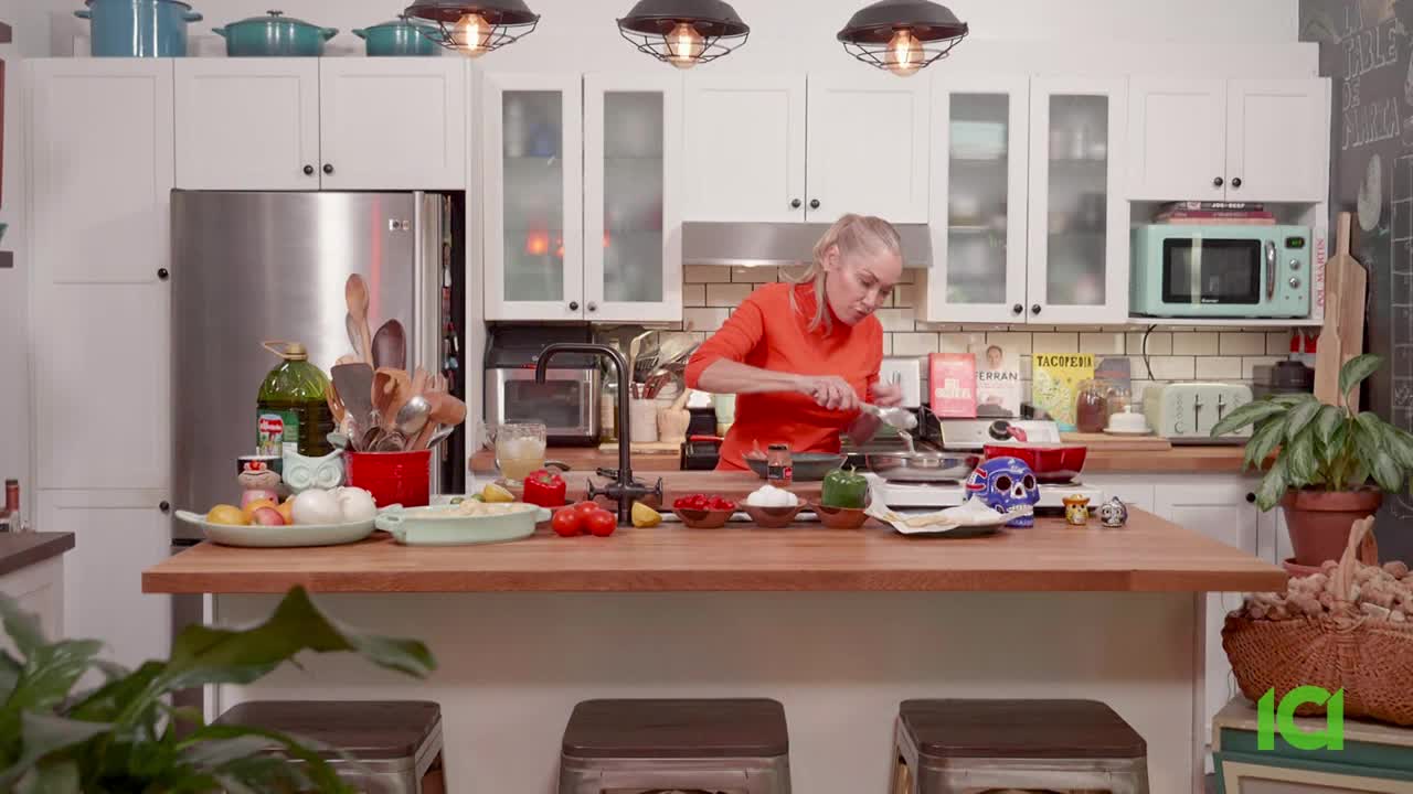 A woman in an orange sweater is cooking in a bright kitchen, preparing ingredients on a wooden counter. The ICI logo is visible in the lower right corner.