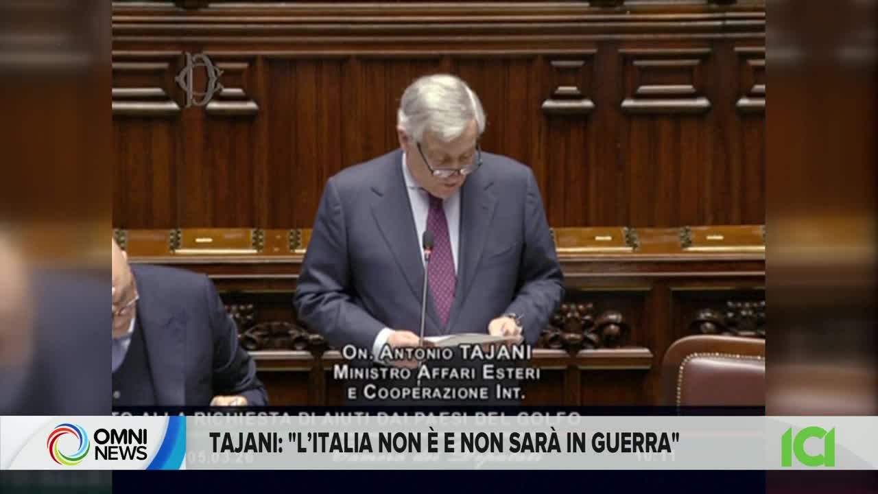 A man in a suit stands at a podium, reading from papers. Below him, a news ticker displays "TAJANI: 'L'ITALIA NON È E NON SARÀ IN GUERRA'".