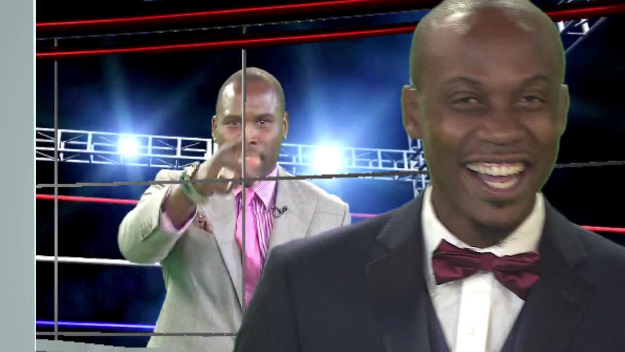 A man in a light suit and pink shirt points directly at the camera, his expression serious. Behind him, a man in a dark suit and maroon bowtie grins broadly. A man in a light suit and pink shirt points directly at the camera, his expression serious. Behind him, a man in a dark suit and maroon bowtie grins broadly.