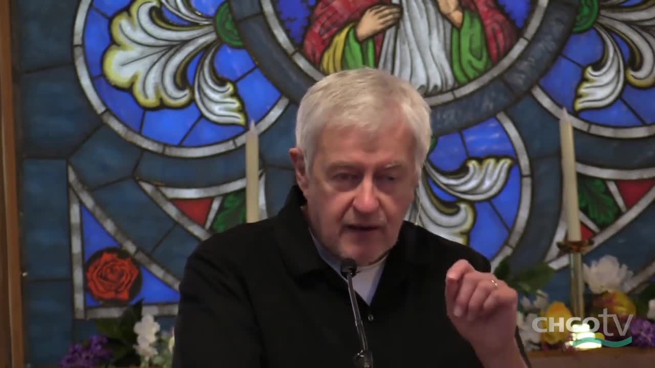 A man with gray hair, wearing a black shirt, gestures with his right hand as he speaks. The CHCO-TV logo is visible in the bottom right corner, and a stained-glass window is behind him.
