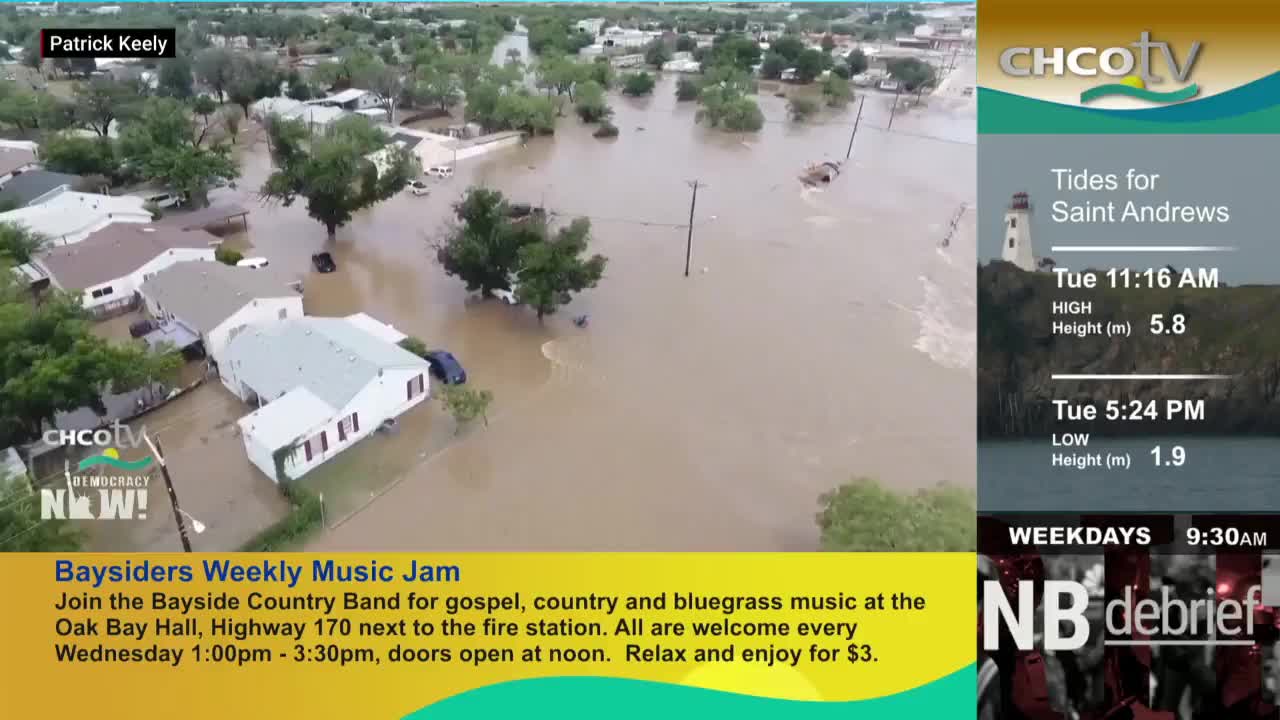 Water fills the streets, surrounding houses and cars. The CHCO-TV broadcast shows the extent of the flooding, with the tide information for Saint Andrews displayed on the side.

