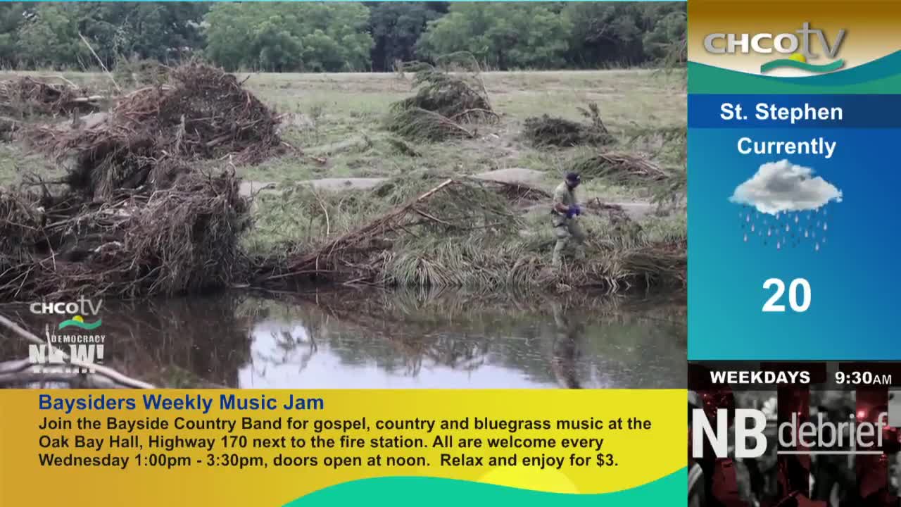 A person in camouflage walks along the water's edge, near a pile of debris. The CHCO-TV weather report shows a rainy day in St. Stephen, New Brunswick.
