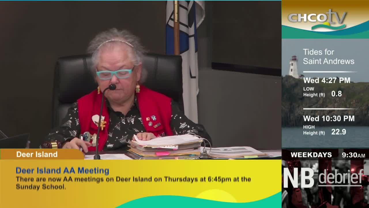 A person in a red vest sits behind a desk, speaking into a microphone. The CHCO-TV logo and tide information for Saint Andrews are displayed on the screen.
