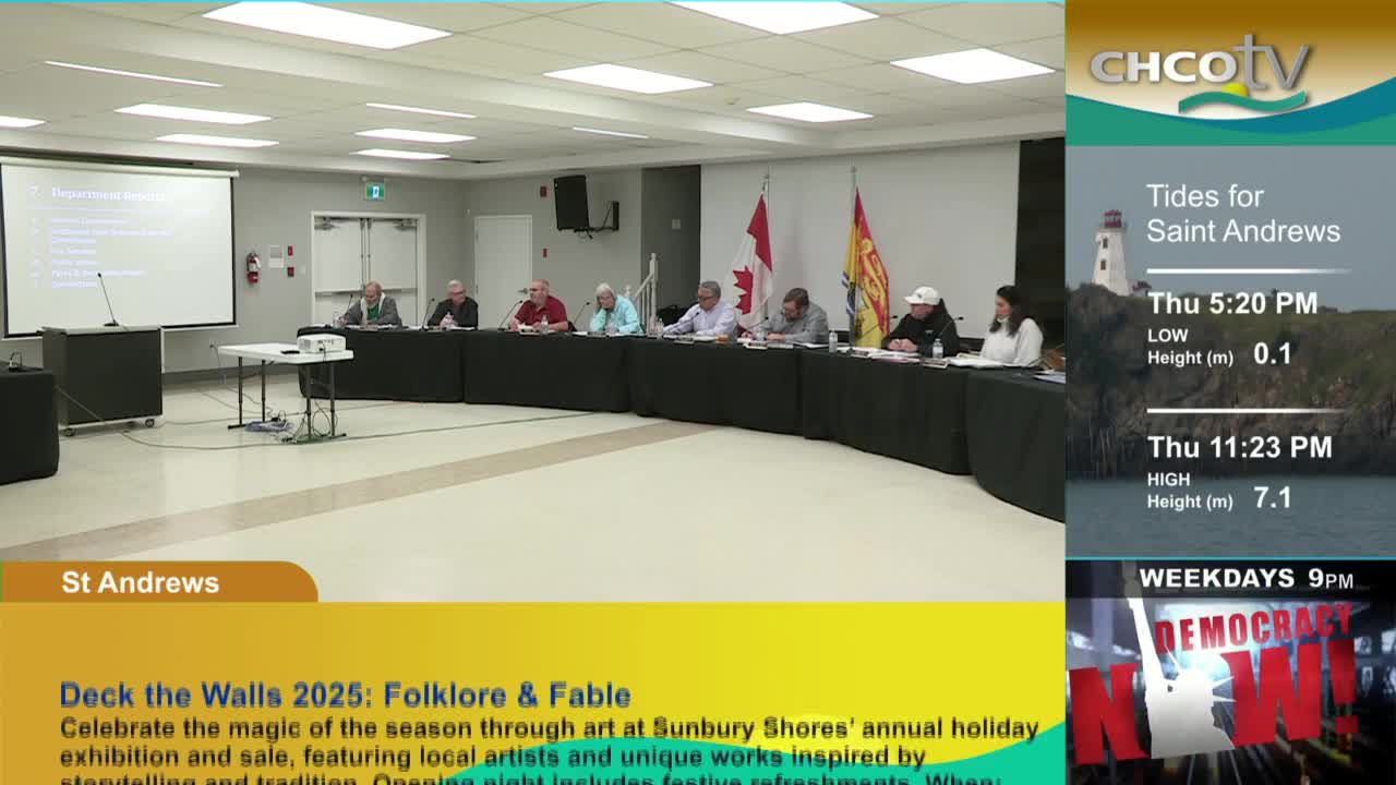 A panel of people, including a few with microphones, sit behind a long, curved table in a room. The Canadian flag hangs behind them, and CHCO-TV's weather report for Saint Andrews is on the right.
