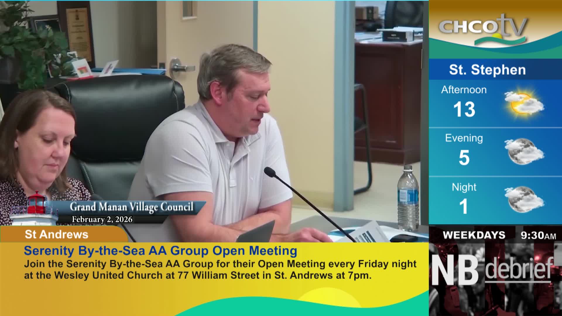 A man in a light grey polo shirt speaks into a microphone at a table. Beside him, a woman with brown hair looks down at papers. A CHCO-TV weather report for St. Stephen shows temperatures dropping from 13 degrees Celsius in the afternoon to 1 degree overnight.