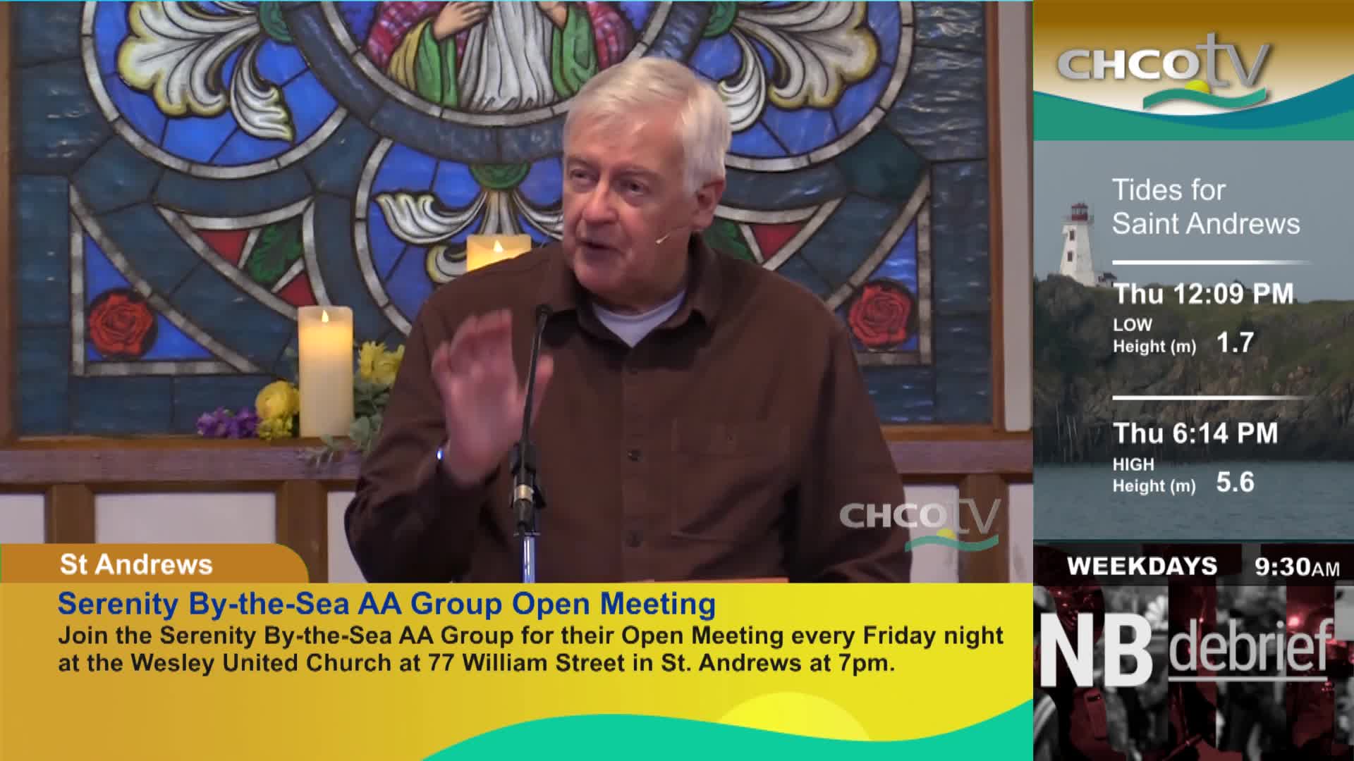 A man with white hair gestures with his right hand as he speaks into a microphone. On the right side of the screen, CHCO-TV displays tide information for Saint Andrews, New Brunswick.