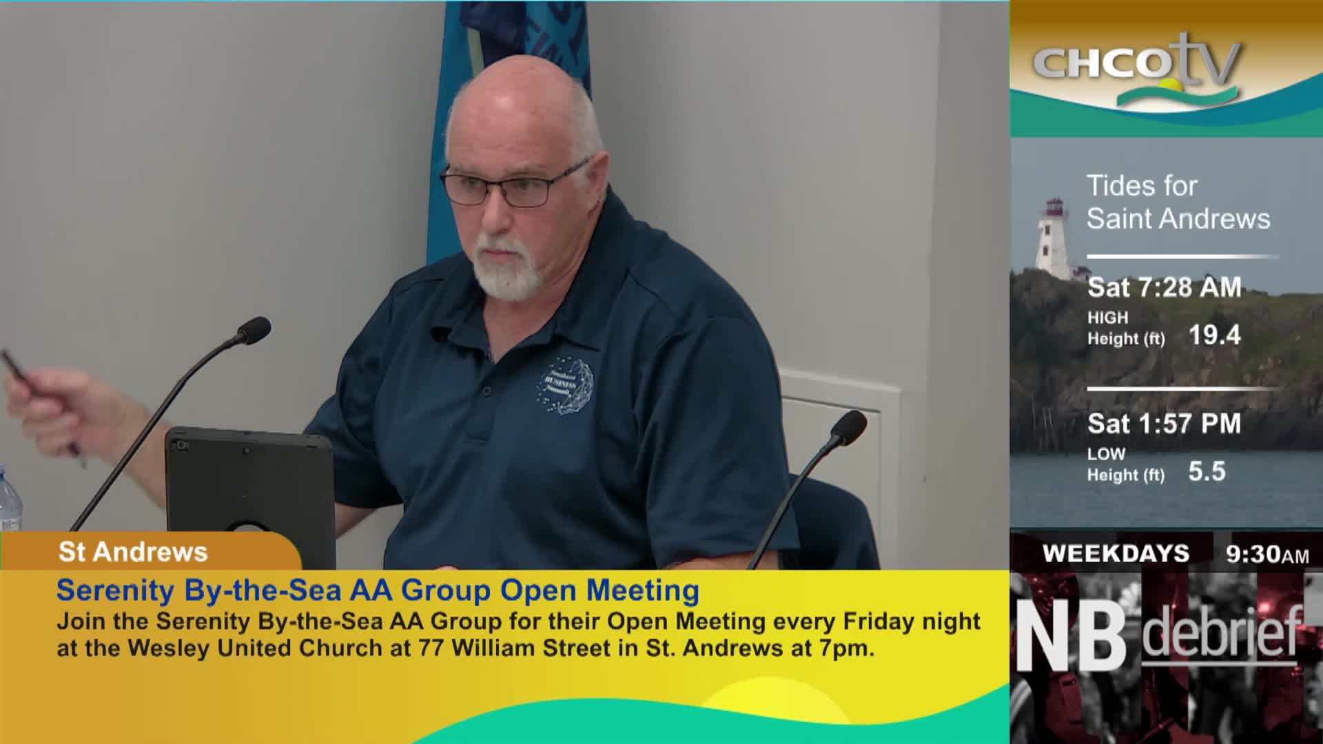 A man in a blue polo shirt is speaking into a microphone. On the right side of the screen, CHCO-TV displays the tides for Saint Andrews.