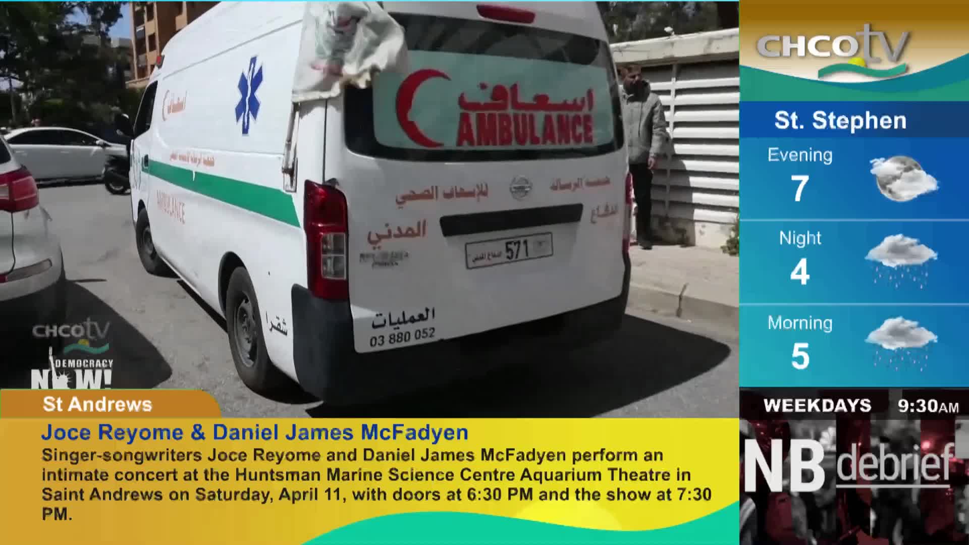 An ambulance with a red crescent logo is parked on the street. A man stands near the back of the vehicle.