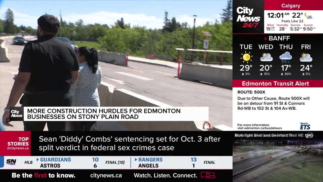 Two people walk along a road blocked by concrete barriers. A car moves in the distance, and the CityNews Calgary logo is visible in the corner.
