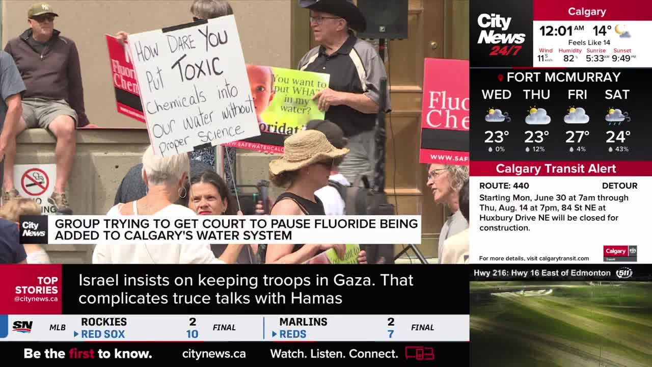 A group of people hold signs protesting fluoride in Calgary's water, visible on CityNews. One sign demands, "How Dare You Put Toxic Chemicals into Our Water."
