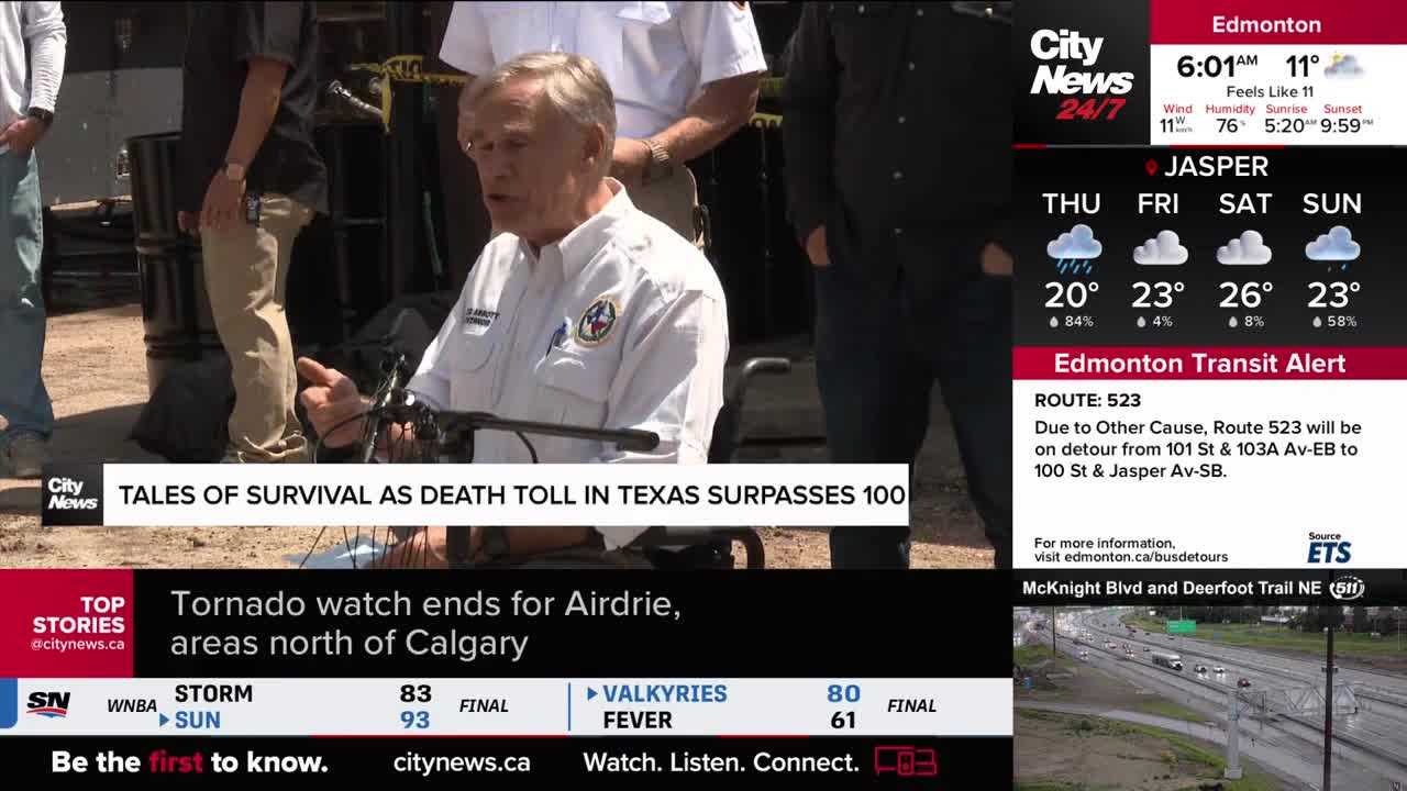 A man in a white shirt speaks into a microphone, seated in a wheelchair. Behind him, a CityNews banner reports on a Texas death toll, while a weather forecast for Edmonton, Canada, is displayed on the right.
