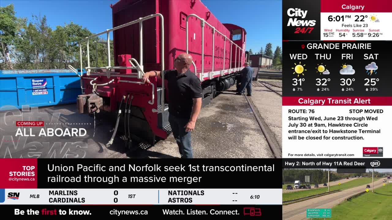 A red train engine sits on the tracks, and two men are inspecting it. The CityNews Calgary graphic in the corner mentions a transit alert.

