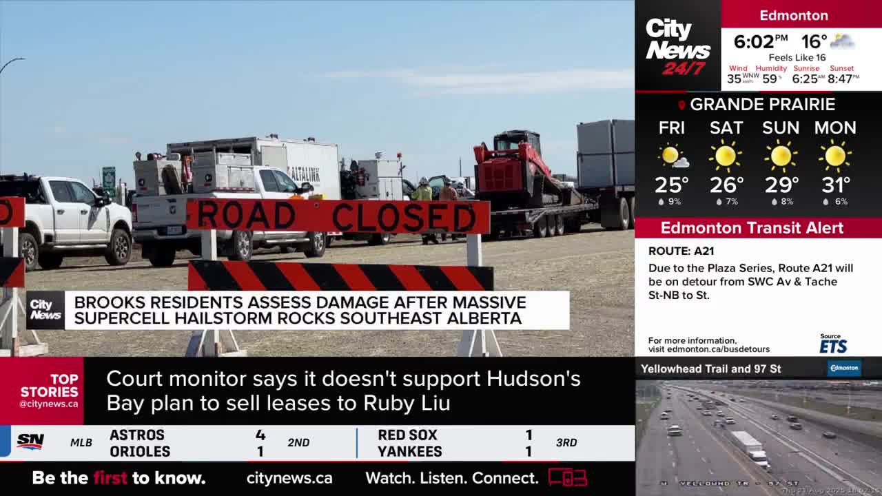 A "ROAD CLOSED" barrier blocks the way, with white trucks and a red tractor-trailer parked behind it. CityNews Calgary is reporting on damage assessment after a supercell hailstorm in southeast Alberta.

