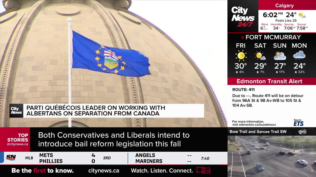 A blue flag with a circular emblem flaps in the breeze against the backdrop of a large domed building. The CityNews Calgary broadcast displays headlines about Canadian politics and weather updates.
