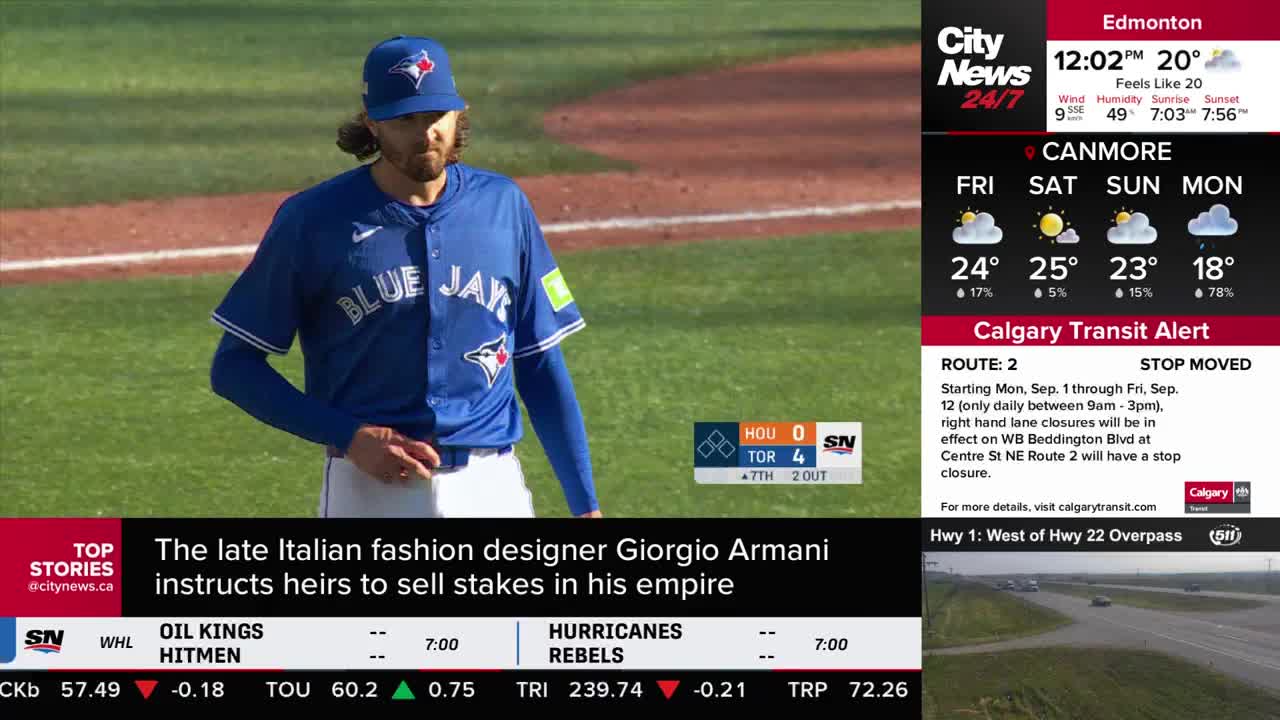 A Toronto Blue Jays pitcher, in a blue uniform, stands on the green grass of the baseball field. The score is displayed on the screen, and CityNews Calgary is reporting on the game.
