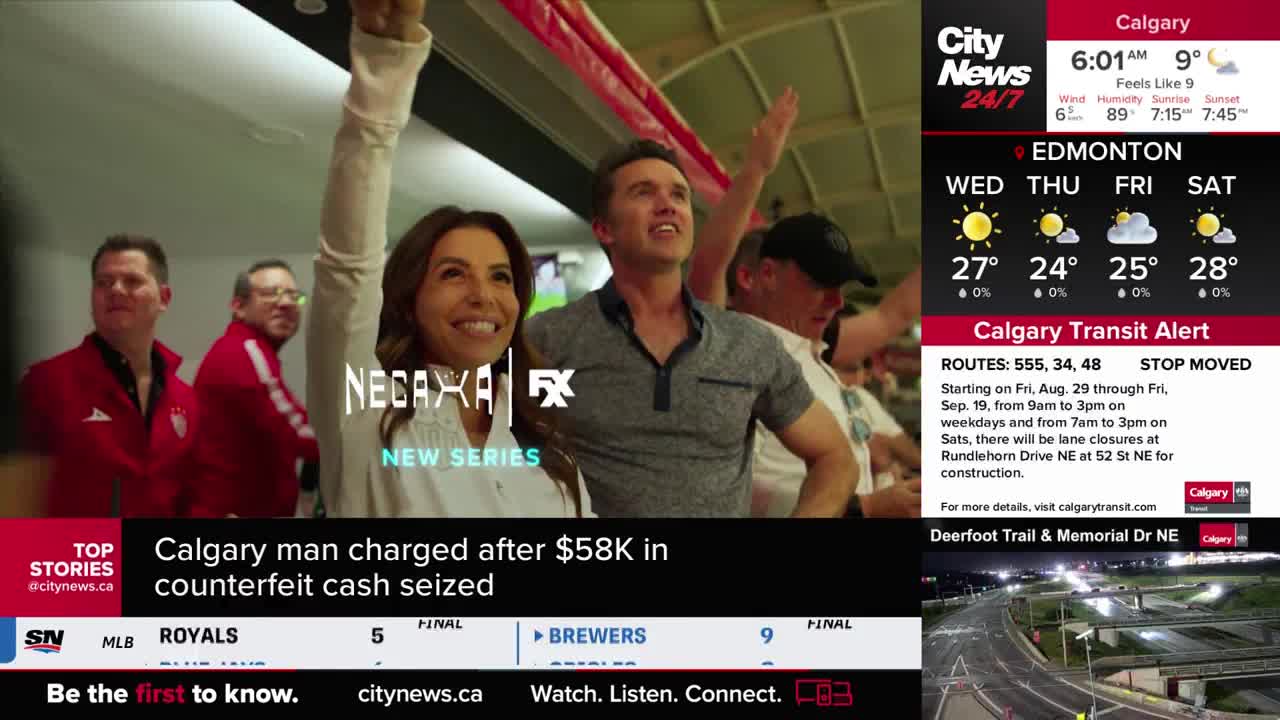 A woman and a man, both smiling, raise their arms with the crowd behind them. The CityNews Calgary weather forecast displays the morning temperature.
