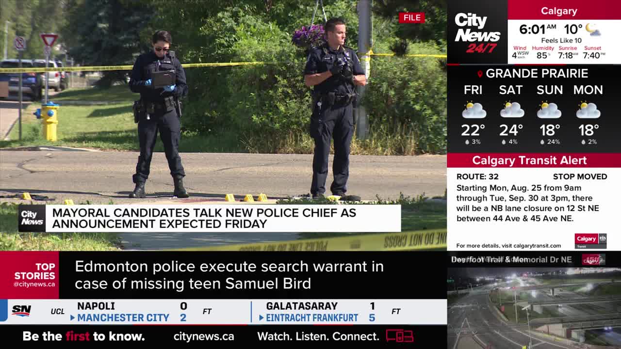 Two Calgary police officers stand watch, one holding a tablet, behind yellow tape. The CityNews Calgary banner at the bottom reports on the search warrant executed by Edmonton police.
