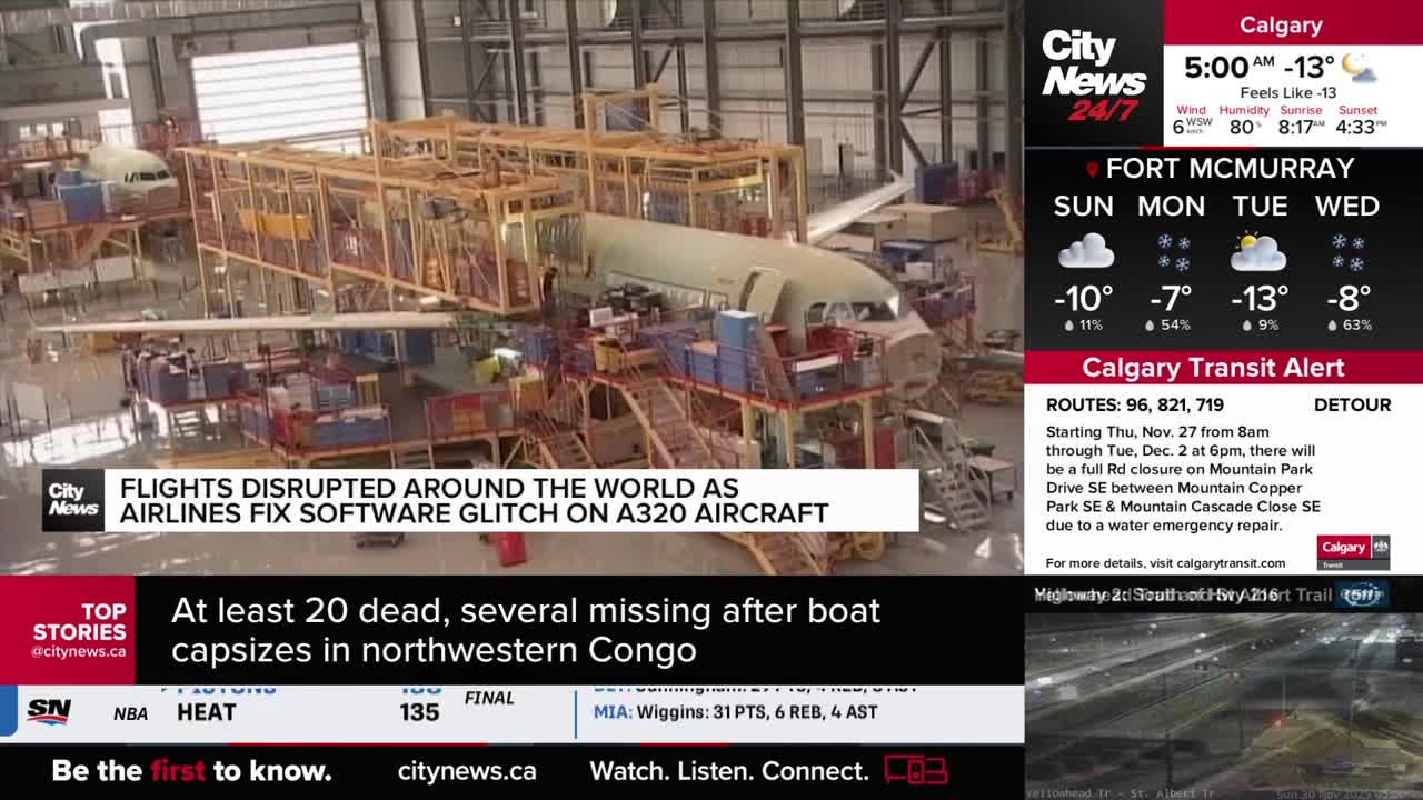 An A320 aircraft fuselage sits in a large hangar, surrounded by scaffolding. The CityNews Calgary broadcast reports on flight disruptions caused by a software glitch.
