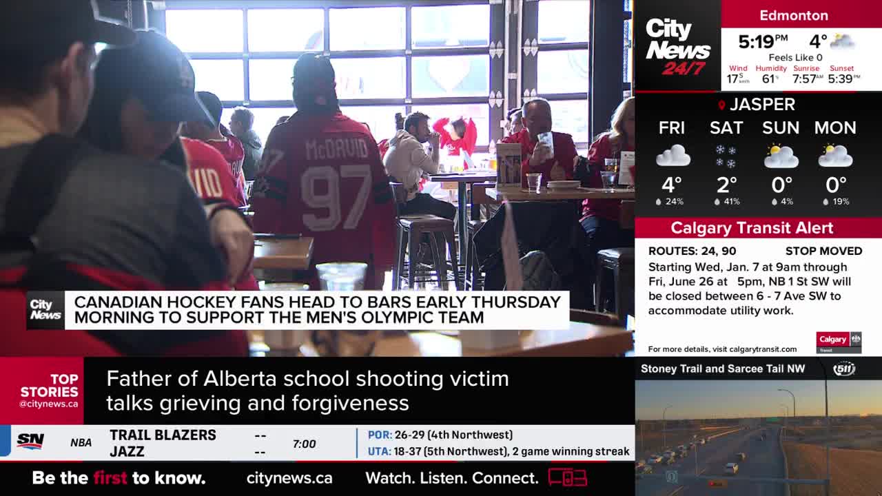 A group of Canadian hockey fans are gathered in a bar, many wearing jerseys. They're looking towards something out of frame, likely watching the Olympic team play.
